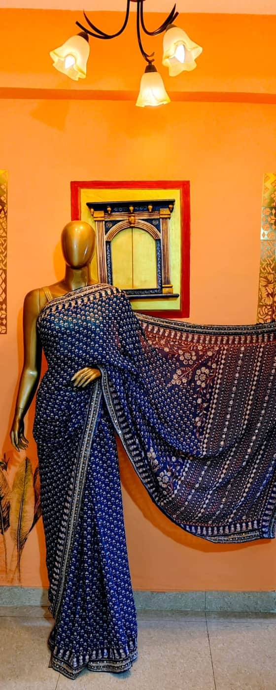 An indigo saree with an embroidered pallu, shown in the showroom