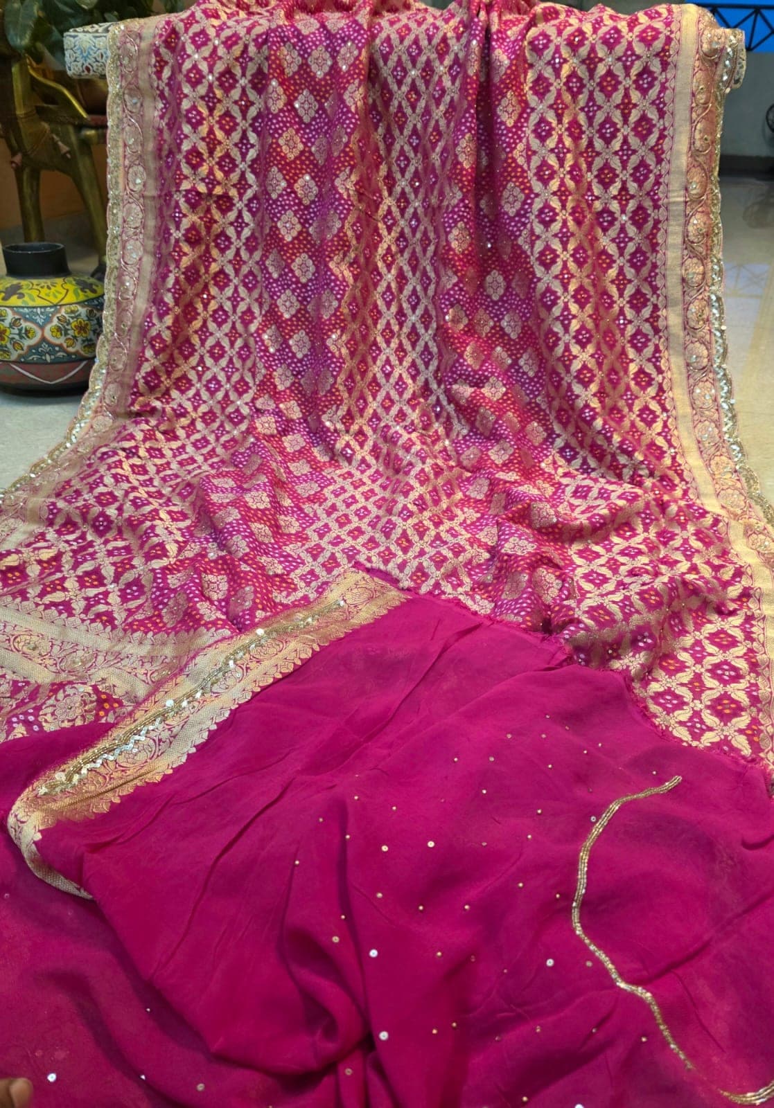 The magenta bandhej saree draped, showing the body and border